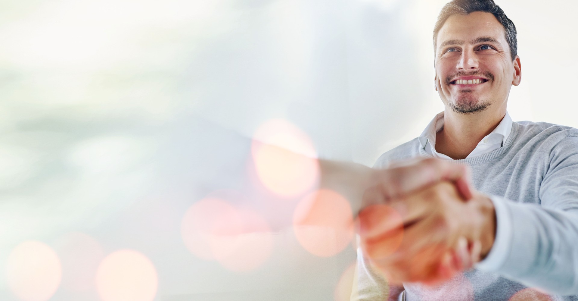 Mockup, handshake and businessman in a b2b meeting for onboarding, job search or contract agreement. Bokeh, hiring space or happy boss shaking hands to welcome a worker in a partnership project deal