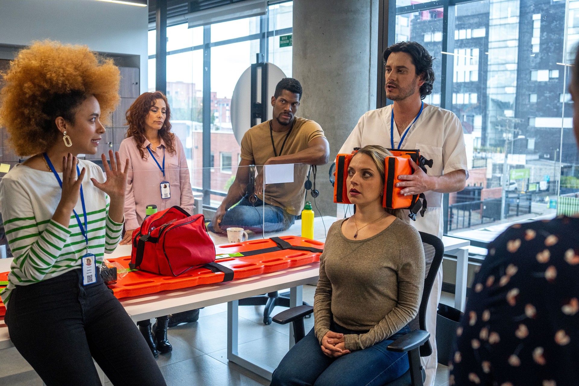 Young physician explaining use of first aid kits at company training session